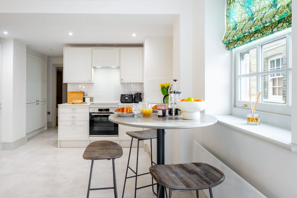 Ground Floor: A dining table with stools for two guests, positioned next to the window