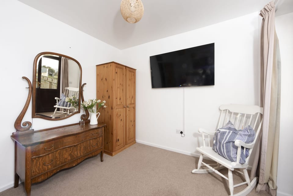 Master Bedroom has a king-size bed, bedside drawers and lamps, and wardrobe Patio doors accessing the decked area.