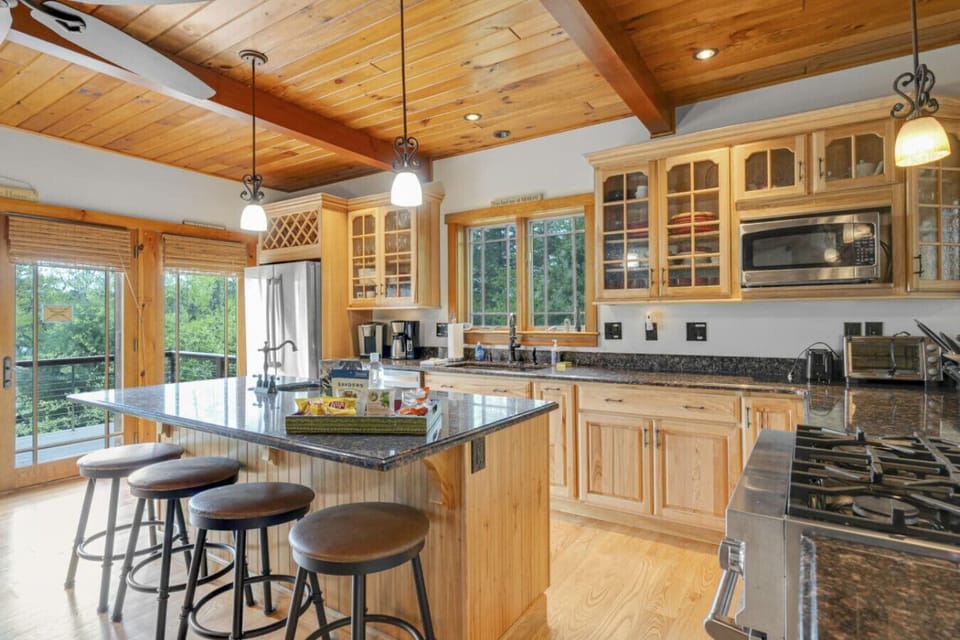 Fully stocked gourmet kitchen with modern appliances and beautiful wood finishes.