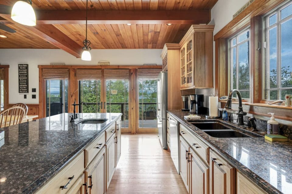 Spacious kitchen featuring a central island, breakfast bar, and serene outdoor views.