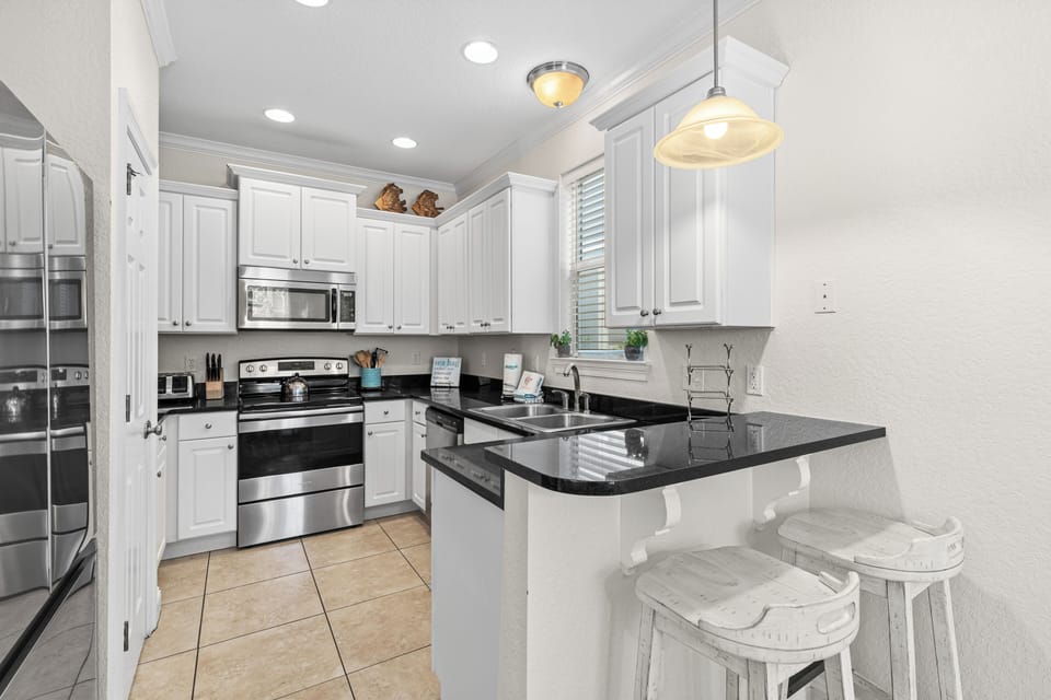 Cook your favorite meals in this bright, fully-equipped kitchen featuring granite countertops, stainless steel appliances, and a convenient breakfast bar.