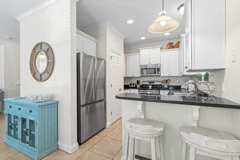 Your fully-equipped kitchen awaits with modern appliances, granite countertops, and breakfast bar seating perfect for morning coffee or casual meals.