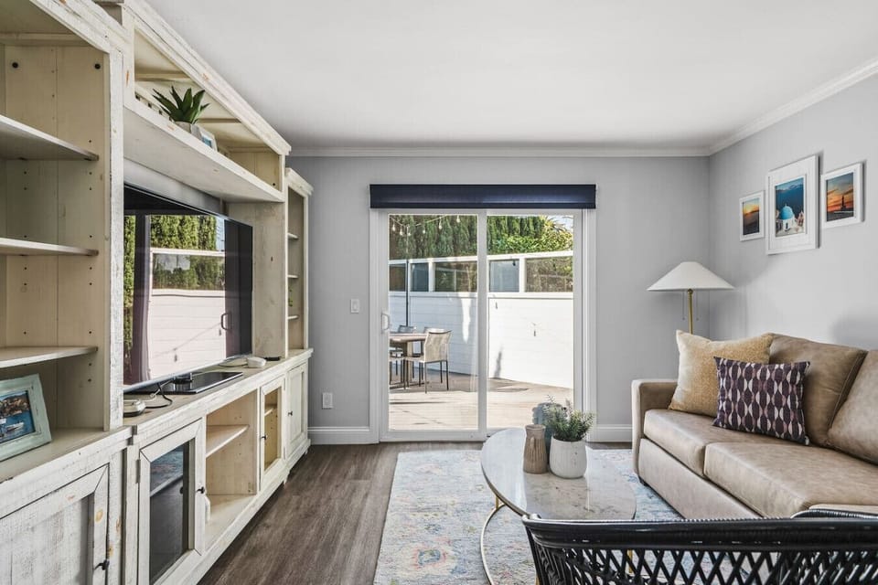 Living room with plenty of seating featuring smart TV with streaming services and easy indoor-outdoor living.