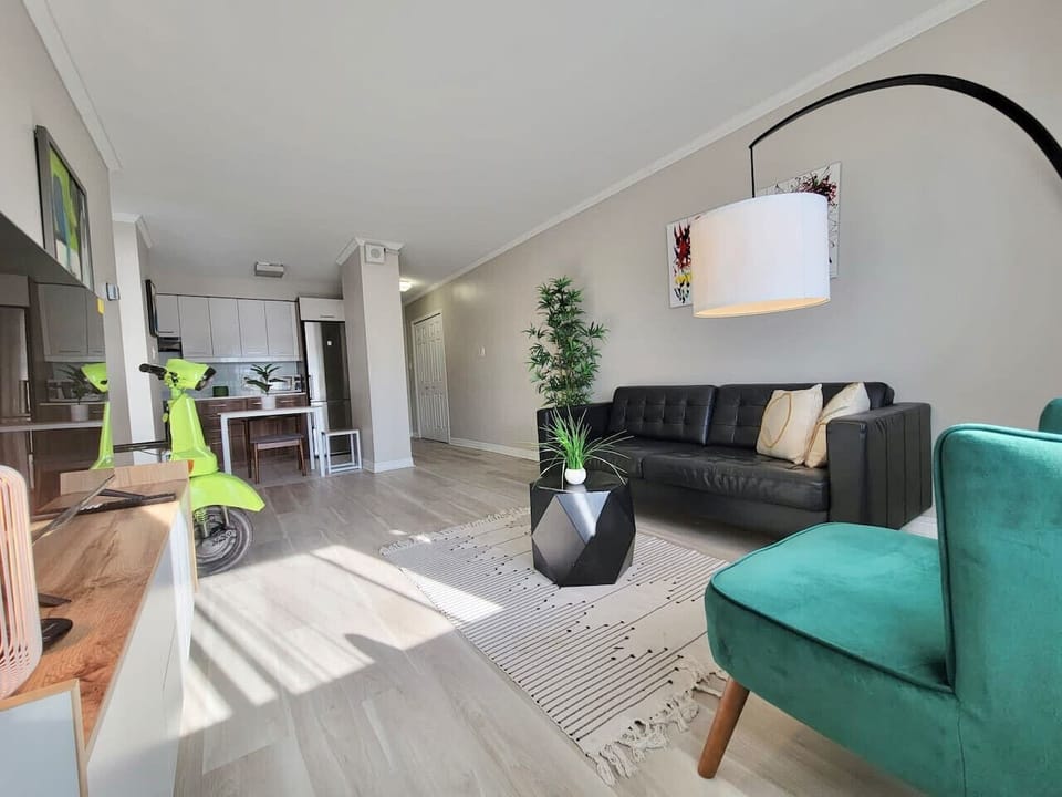 A fresh and inviting lounge area with sophisticated décor, a lush indoor plant setting, and a welcoming ambiance.