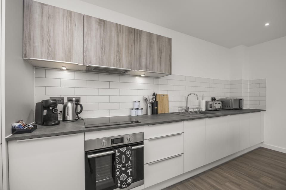 Modern kitchen with electric hob, oven, microwave, and coffee machine