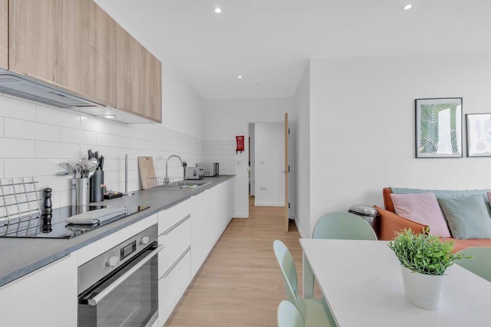 Fully equipped kitchen with sleek countertops, oven, stovetop, microwave, and ample storage space.