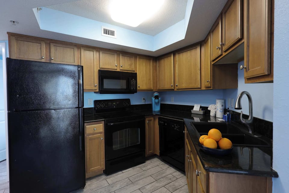 Feel right at home in this fully equipped kitchen featuring sleek black appliances, granite countertops, and all the essentials—perfect for cooking up your favorite meals during your Myrtle Beach getaway!