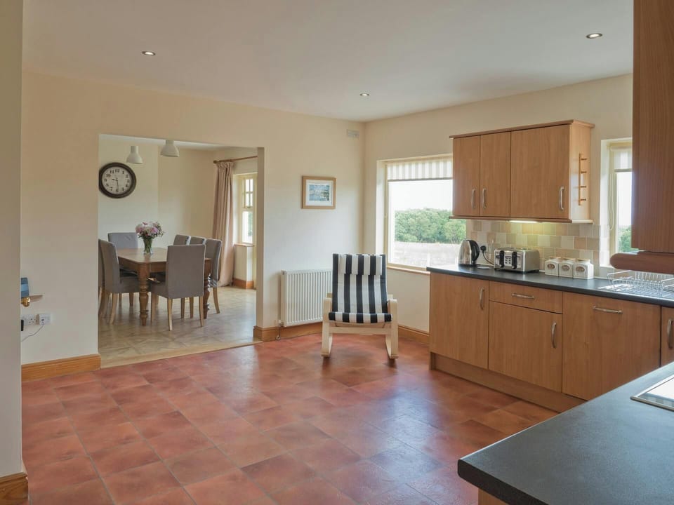 Kitchen, striped chair, clock on the wall in the dining room