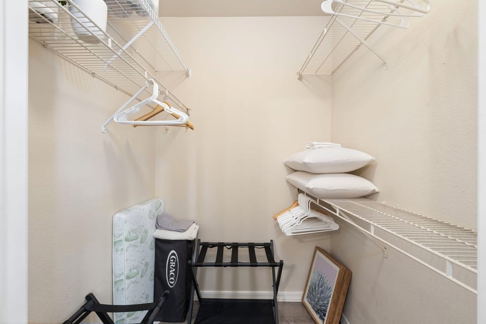 Walk-in closet with luggage racks and extra pillows