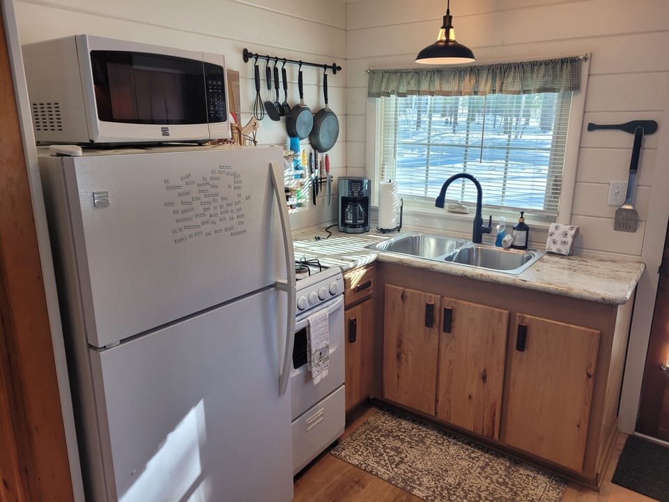 KITCHEN:  The cabin has a cute little kitchen with all appliances except for a dishwasher.  Includes a good supply of cooking and dining utensils as well.