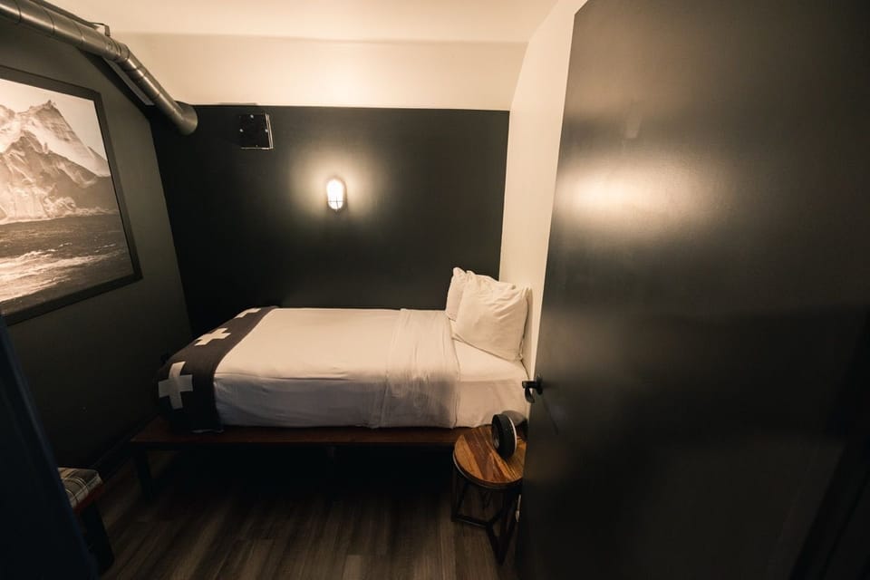Stylish and intimate Pod Room with a dark, moody ambiance, perfect for a peaceful and cozy stay.