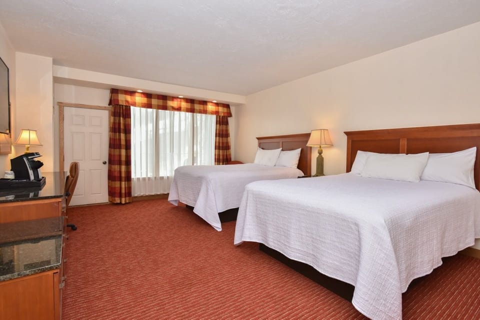 Spacious bedroom with two plush beds, warm lighting, and a cozy ambiance for a comfortable stay.