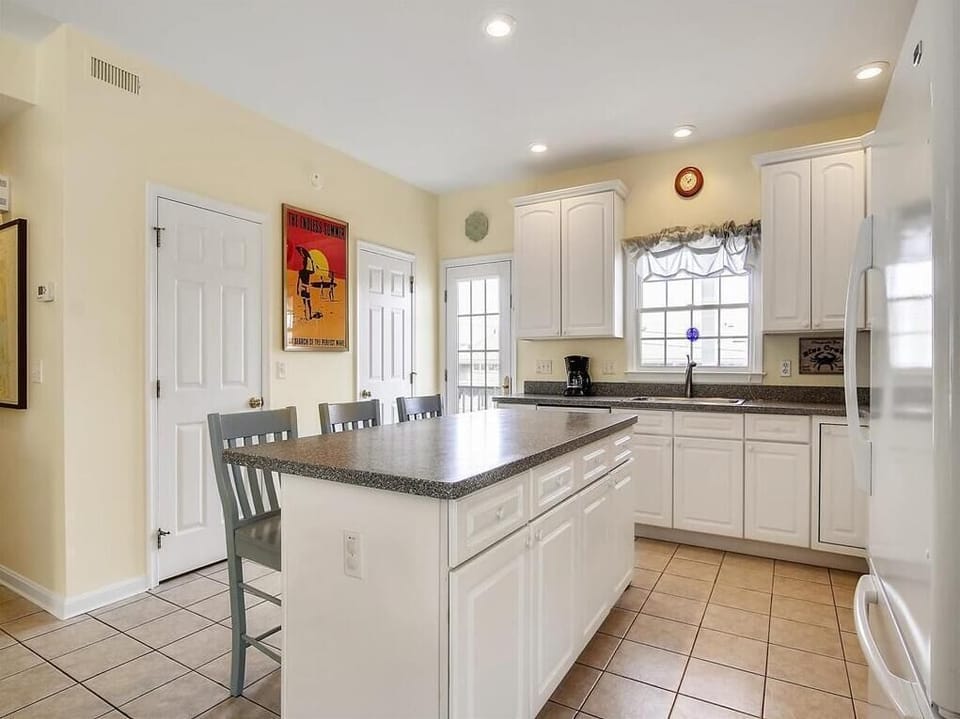 Fully equipped coastal kitchen with modern appliances, ample counter space, and bright natural light.