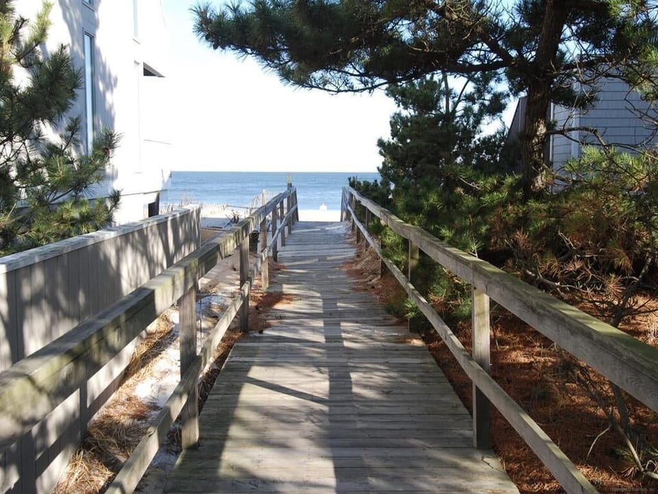 Scenic boardwalk leading directly to the ocean, surrounded by lush coastal greenery.
