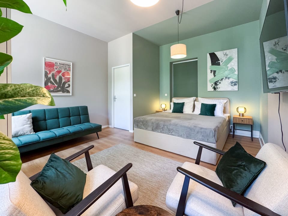 Green bedroom with double bed and sofa bed