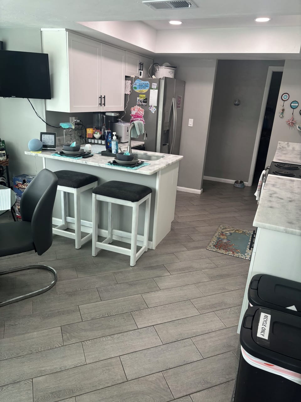 Eat in kitchen work quartz countertops, stainless appliances and 2 barstools