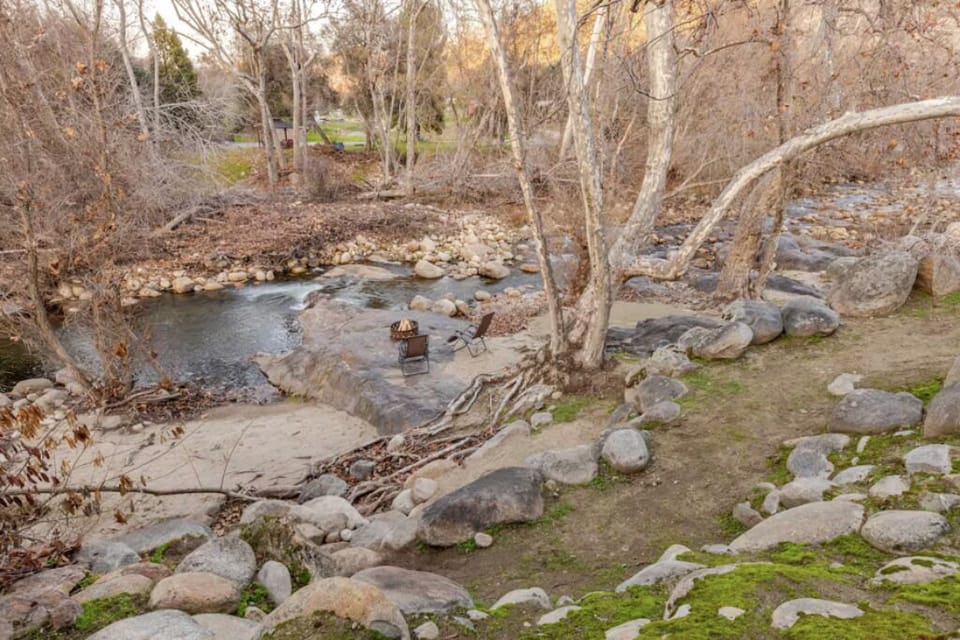 Spacious patio with a grill, dining table, fire pit, and a beautiful river view.