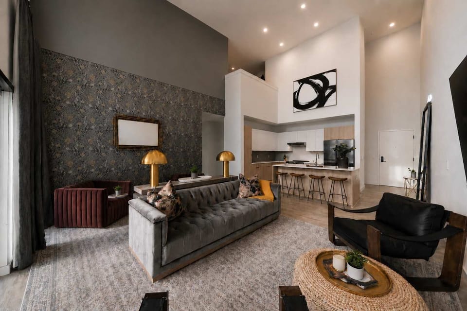Stunning open-concept living space, tall ceiling and stylish patterned accent wall, and comfortable seating area.