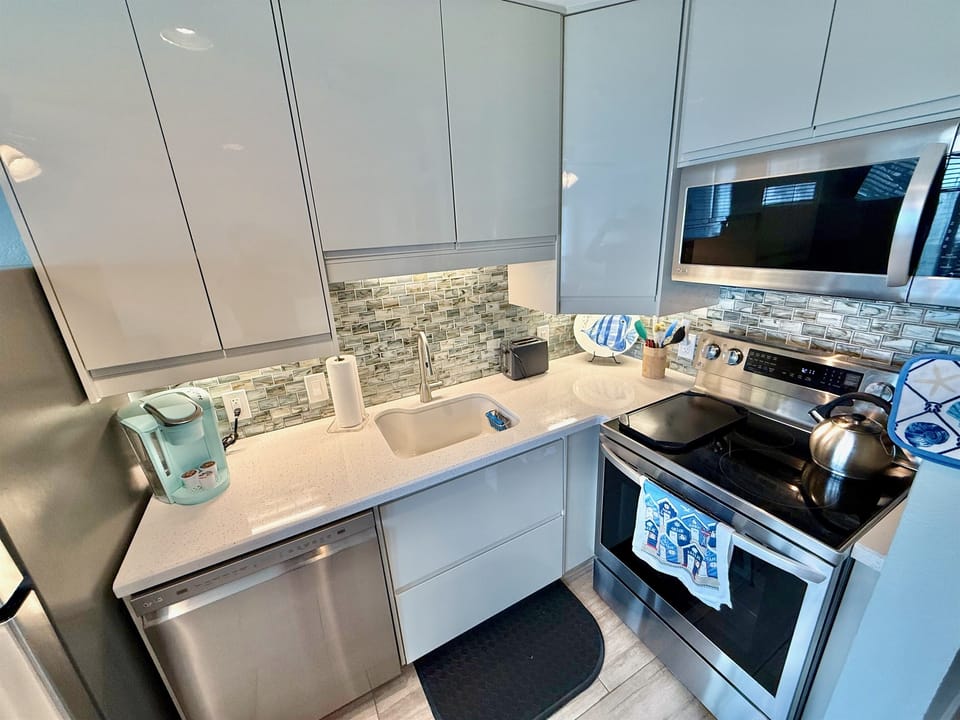 Cook with a view—fully stocked modern kitchen with stainless appliances, large cabinets, and everything you need for sunset dinners or casual beach bites.