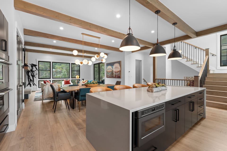 Gather in this open-concept space where rustic wood beams frame your culinary adventures and shared meals around the dining table.