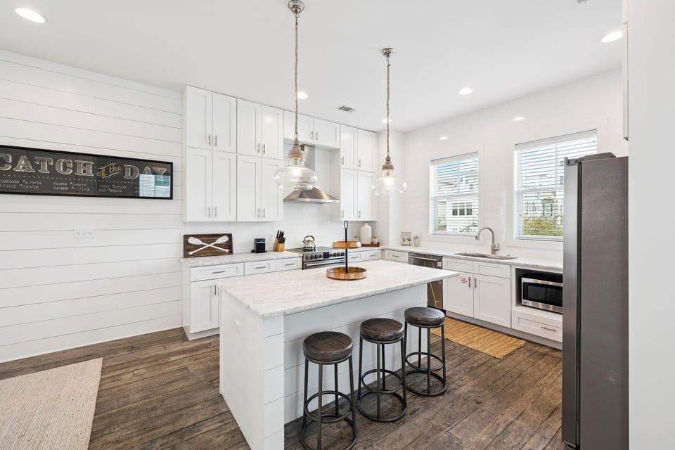 Your spacious kitchen invites culinary adventures with gleaming white cabinets, granite island, and modern appliances perfect for memorable meals.