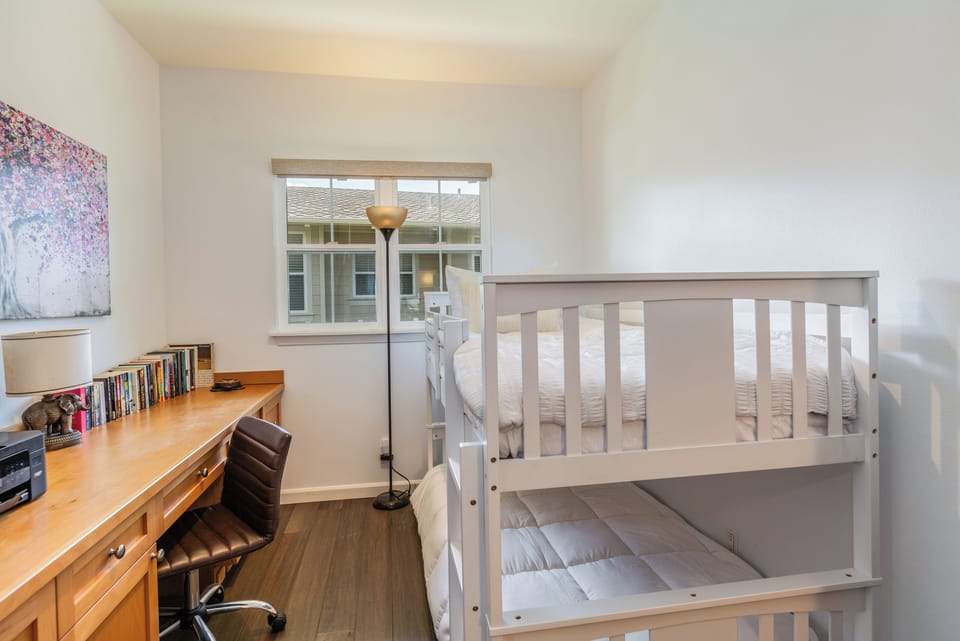 Cozy bunk room with a built-in desk, perfect for kids or remote work.