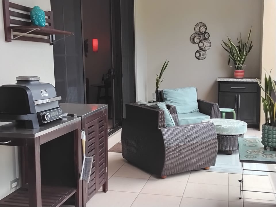 Sitting area on covered balcony with BBQ