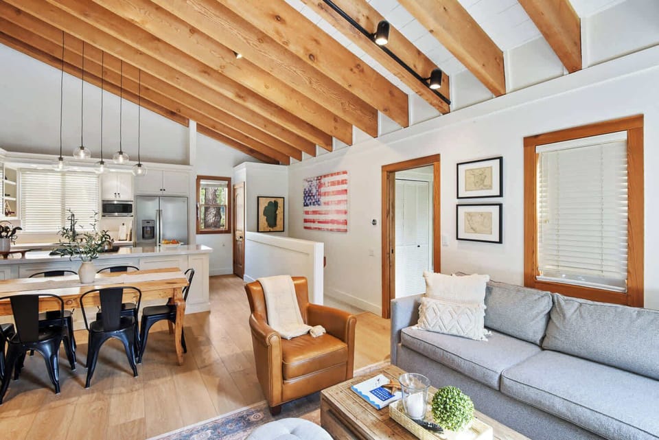 Open Living space with pull out sofa, TV, fireplace, and balcony