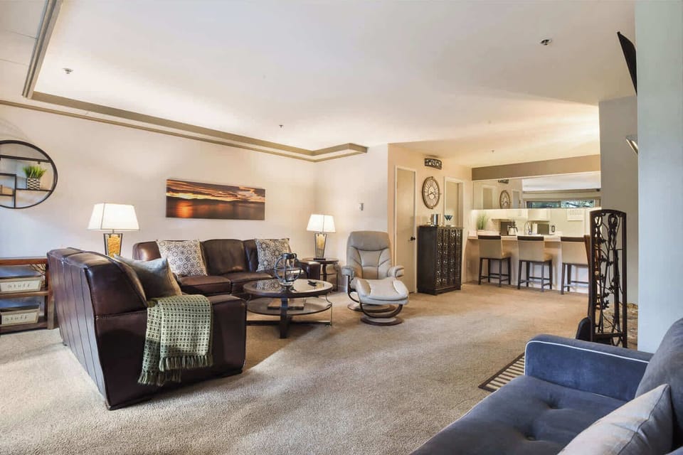 Open living space with sofa sleeper, Smart TV, wood fireplace, and balcony