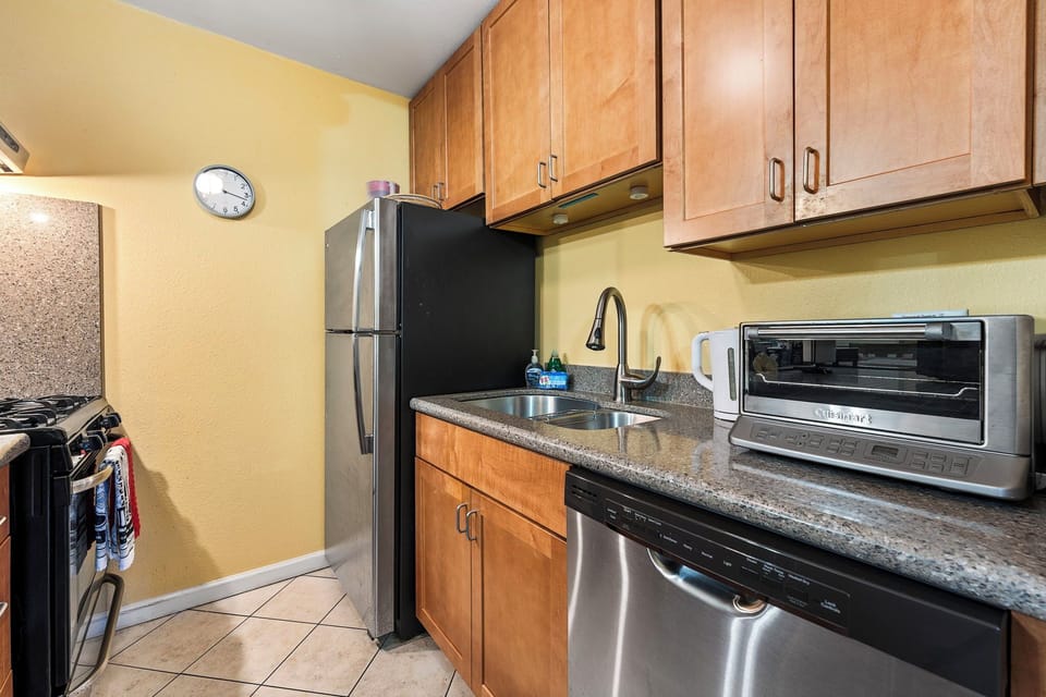 Full kitchen with stove, microwave, fridge, coffee maker, and cookware.