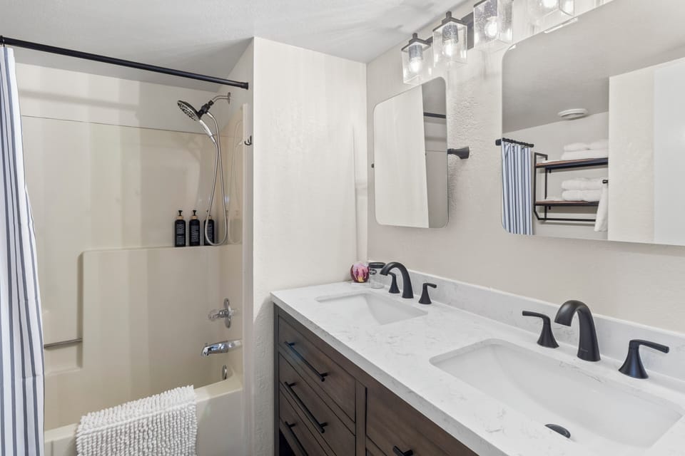 Remodeled guest bath w/ dual vanity and tub/shower combo. 