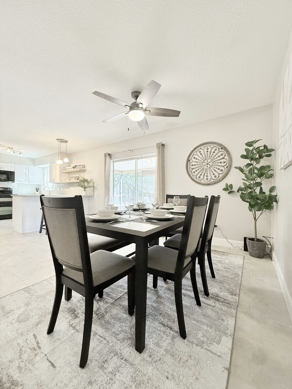 Features a ceiling fan, dining table for 6, breakfast bar with two bar stools.