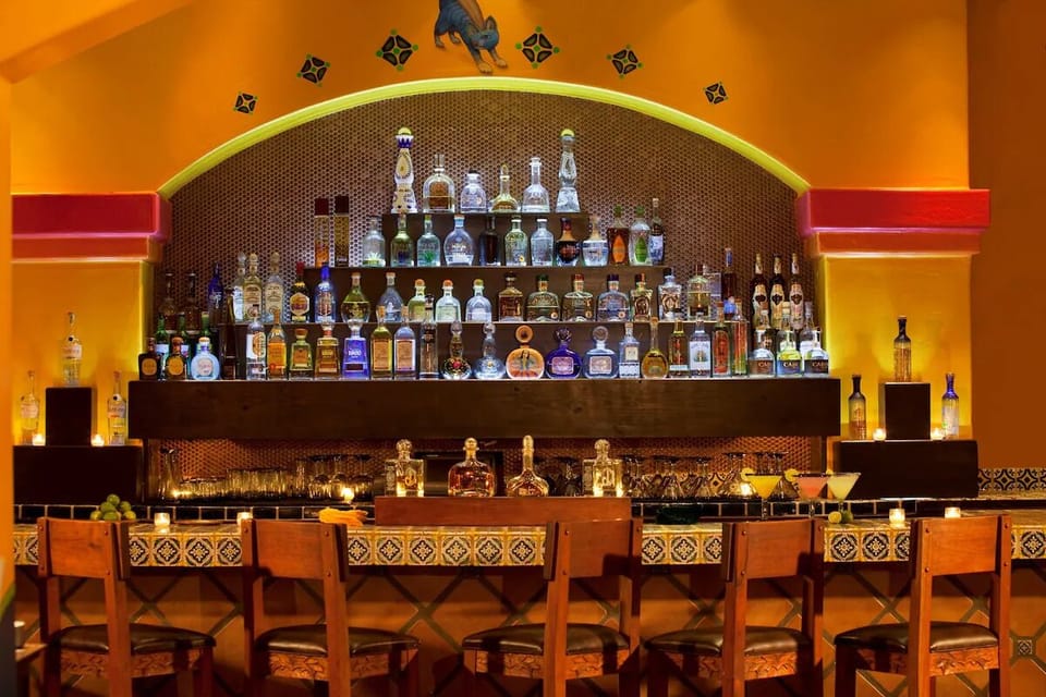 Sip handcrafted cocktails at a vibrant bar glowing with warmth.