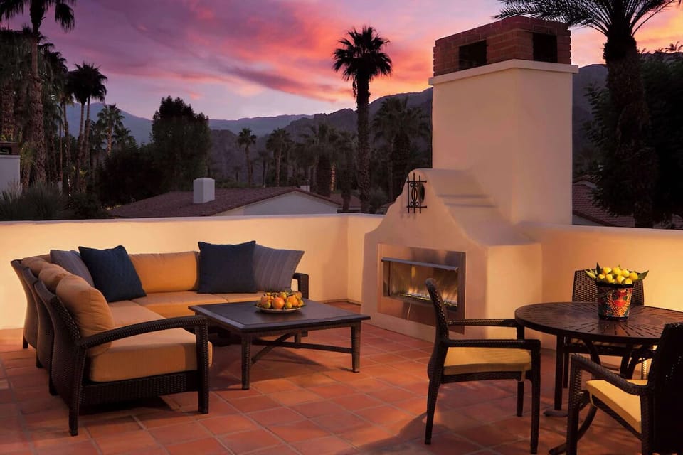 Unwind at sunset by the rooftop fireplace with desert views.