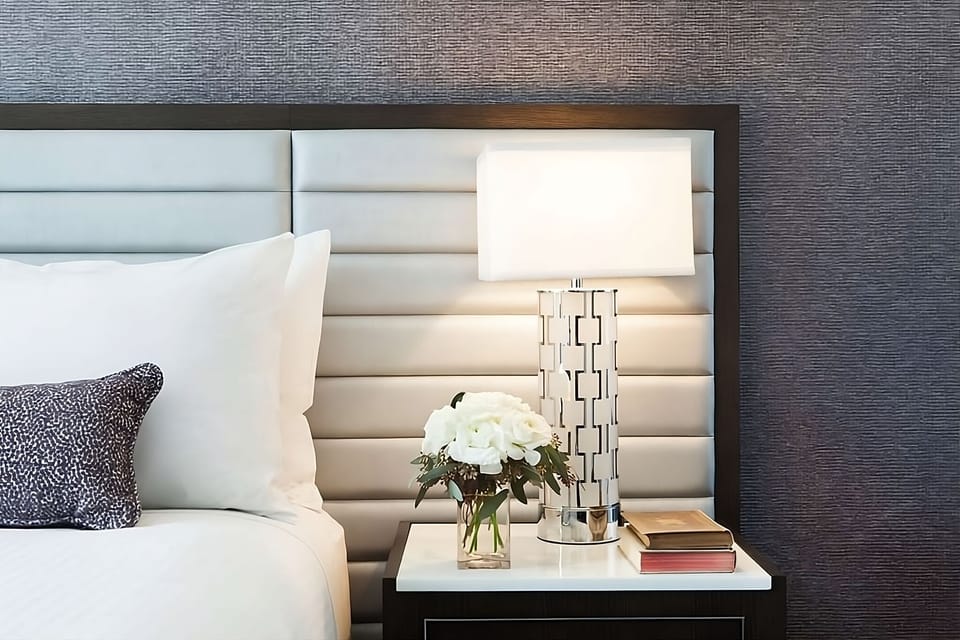 Sip morning coffee beside crisp linens and modern bedside decor.