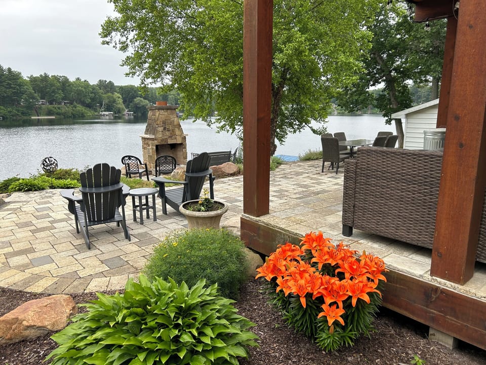 Back patio overlooking the water and outdoor fireplace 
