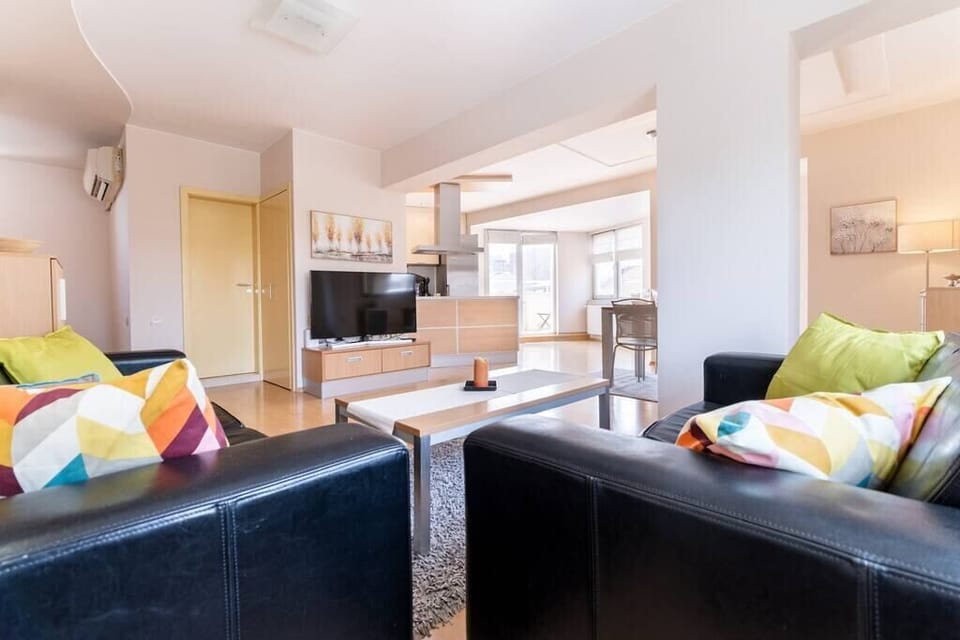 Spacious living room with comfortable sofas and a dining table with a lot of natural light. 