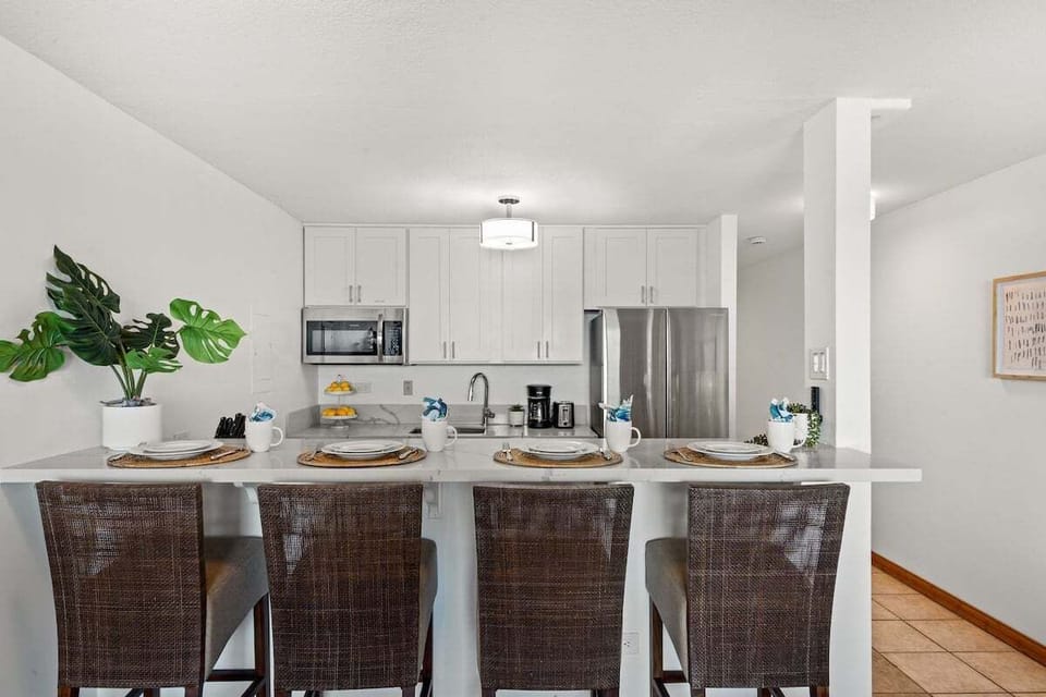 Fully equipped kitchen with granite countertops, modern appliances, and seating for four