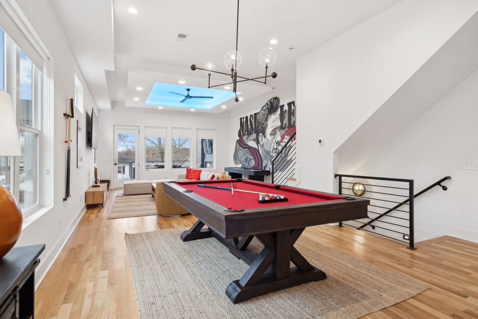 Living Room: Challenge your friends to a game of pool while enjoying the open-concept design and Nashville-inspired artwork.