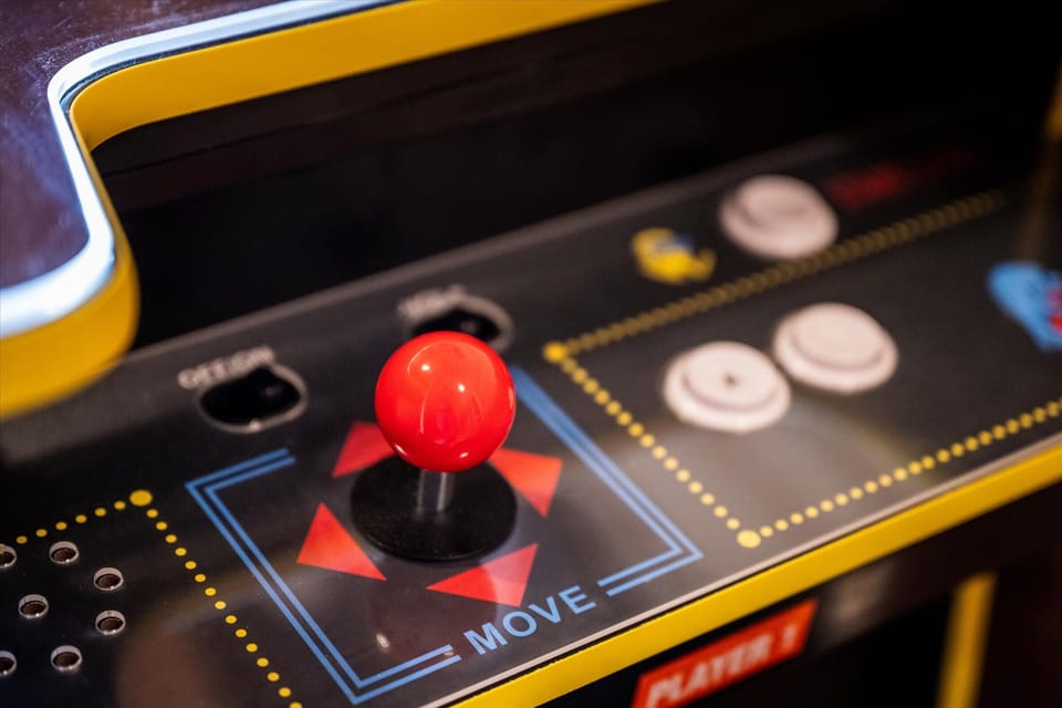 A close-up of a vintage-style arcade game console, featuring a joystick and colorful buttons for endless entertainment.