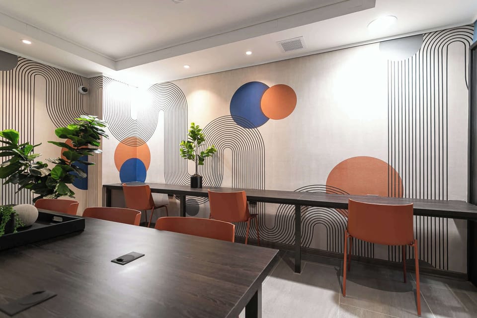 Experience modern elegance in this stylish workspace, featuring unique wall art and cozy seating for a perfect blend of comfort and creativity.