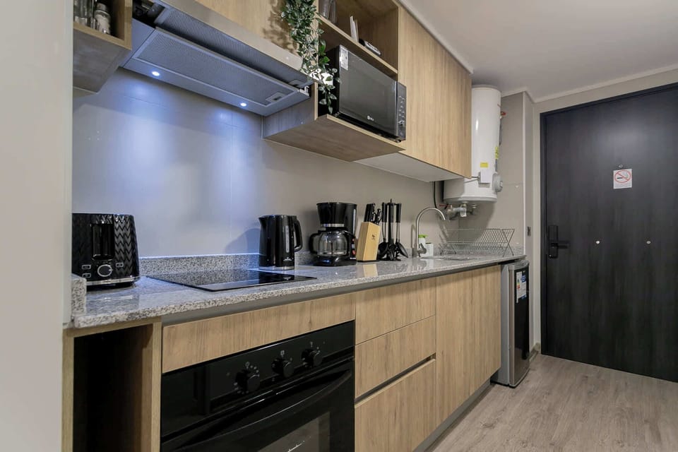 Sleek and fully-equipped kitchen with modern appliances, perfect for preparing meals in your cozy studio retreat.