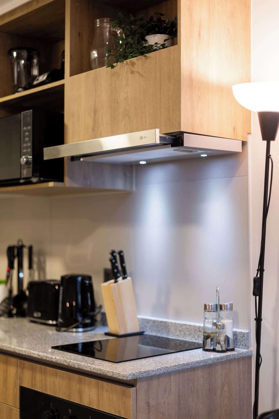 Modern kitchen with sleek appliances and warm wooden accents, perfect for cooking a cozy meal.