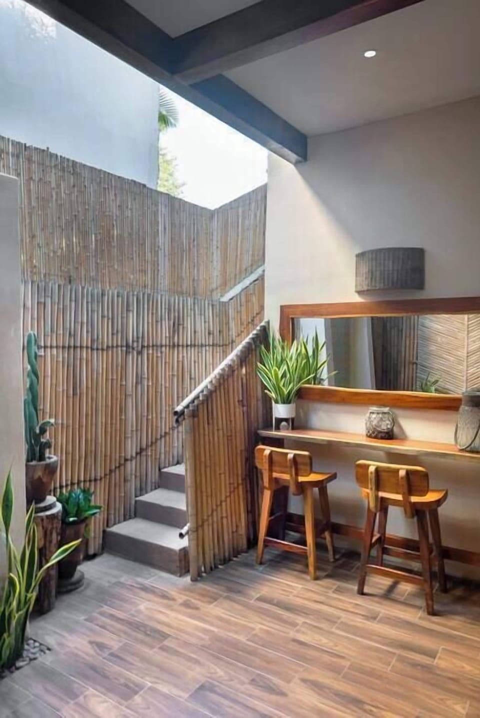 Small wooden bar with seating, located next to the staircase that connects to the second floor