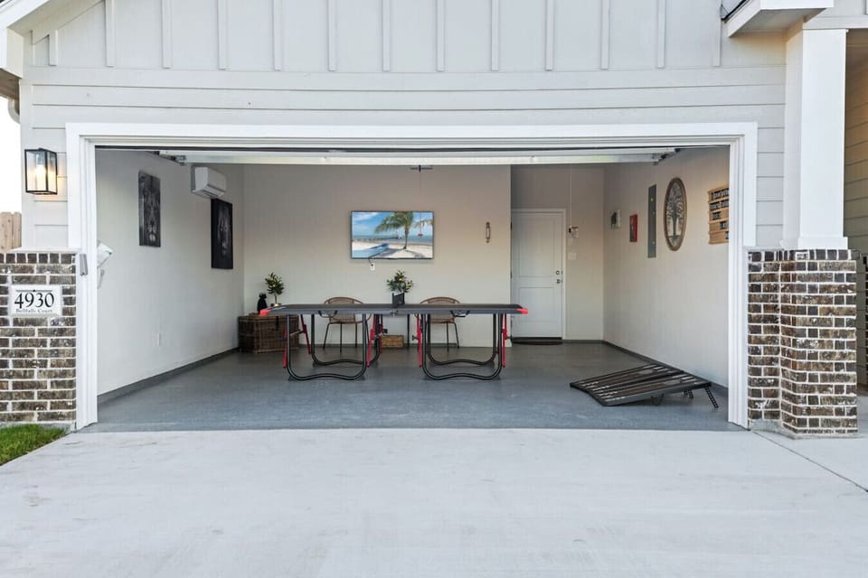 Garage game room with ping-pong table, visible from the exterior.