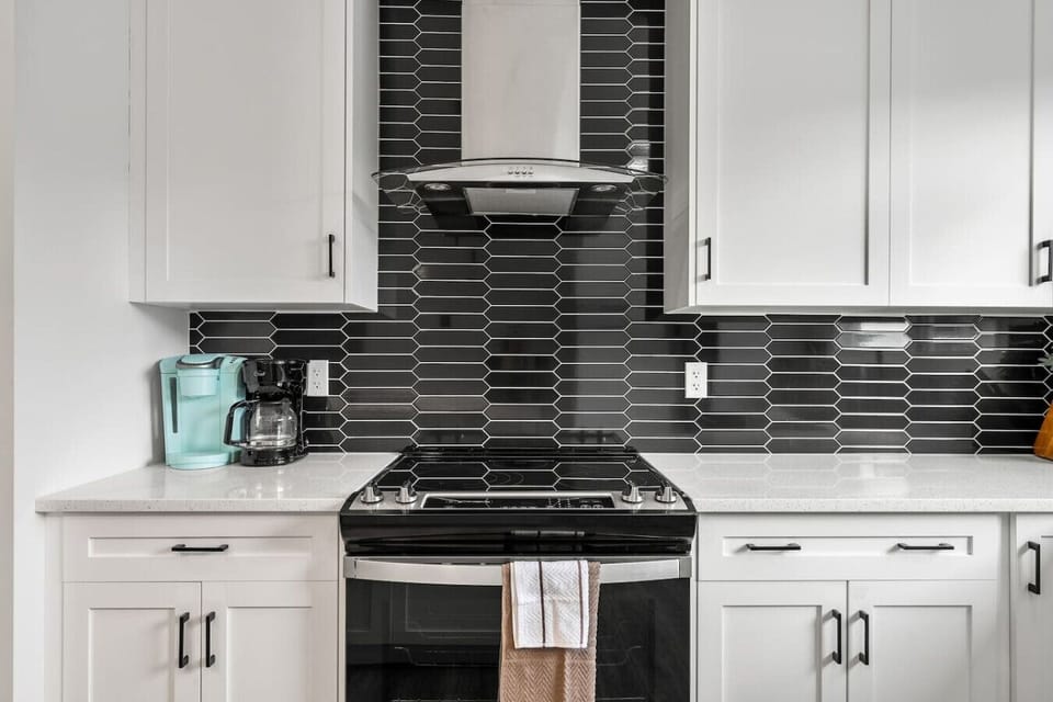 Full kitchen with drip & Keurig coffee makers, a blender, rice cooker & a large island.