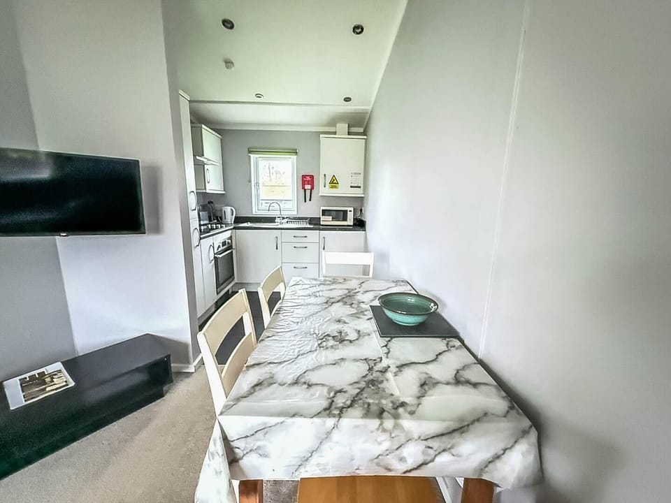 Sleek dining area with marble table and modern kitchen view