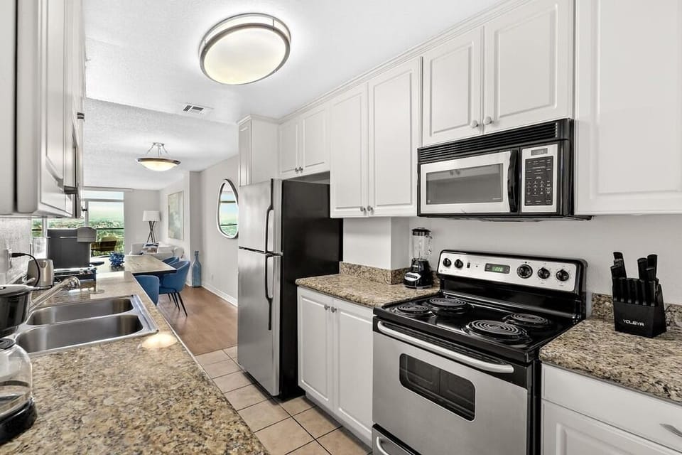Modern stainless steel appliances and abundant white cabinetry.