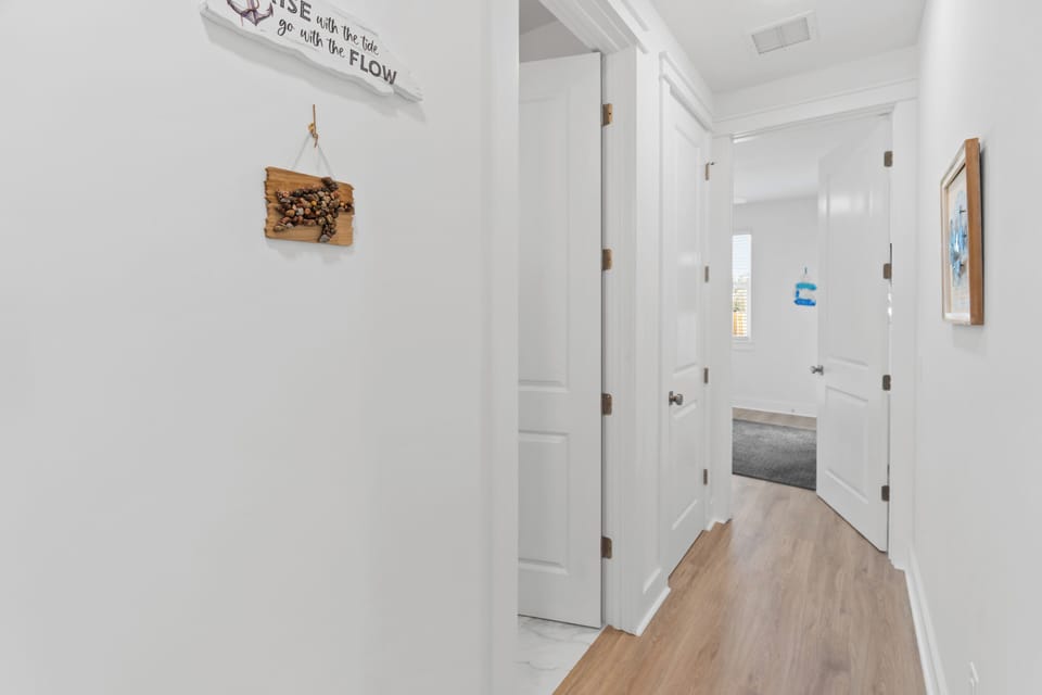 Step into your bright hallway with warm wood floors leading to cozy spaces throughout your home.