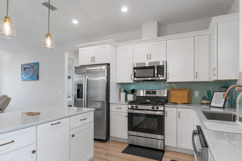 Step into your bright, modern kitchen with pristine white cabinets and stainless steel appliances ready for your culinary adventures.